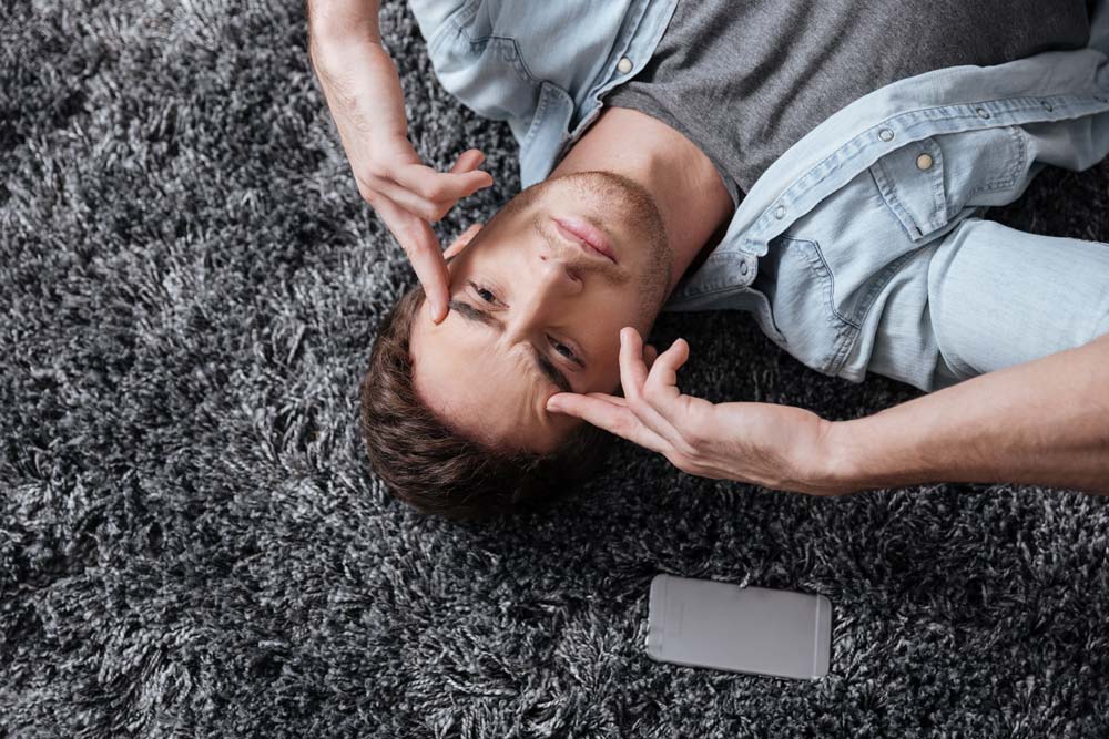 close up portrait of a casual man lying on a carpet and intensely thinking SBI 302836888